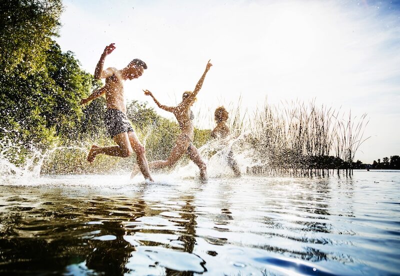 Freunde-die-zusammen-im-Wasser-im-See-plantschen
