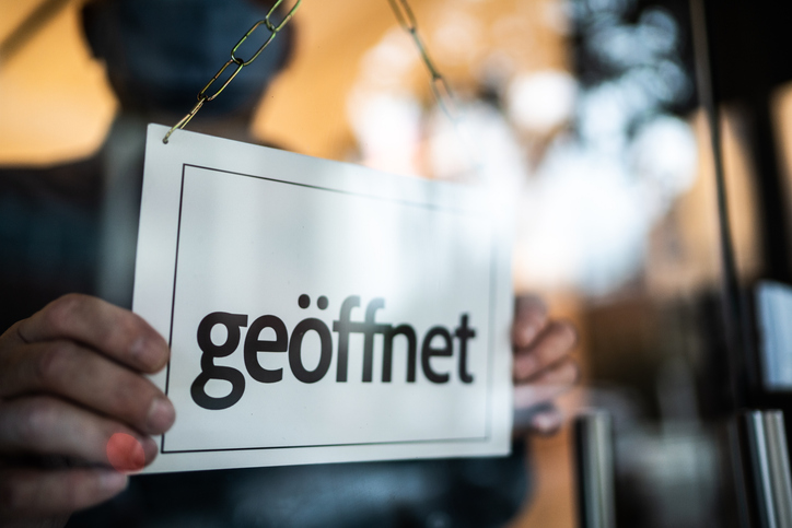 Geöffnet Schild wir mit beiden Händen umgedreht